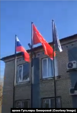 Прапори, вивішені перед селищною радою Новоолексіївки 5 березня 2022 року