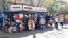 Люди біля сувенірної крамниці в центрі Феодосії напередодні початку курортного сезону, 15 квітня 2024 року