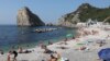 Відпочинок на березі Чорного моря на тлі скелі Діва в селищі Сімеїз, серпень 2021 року