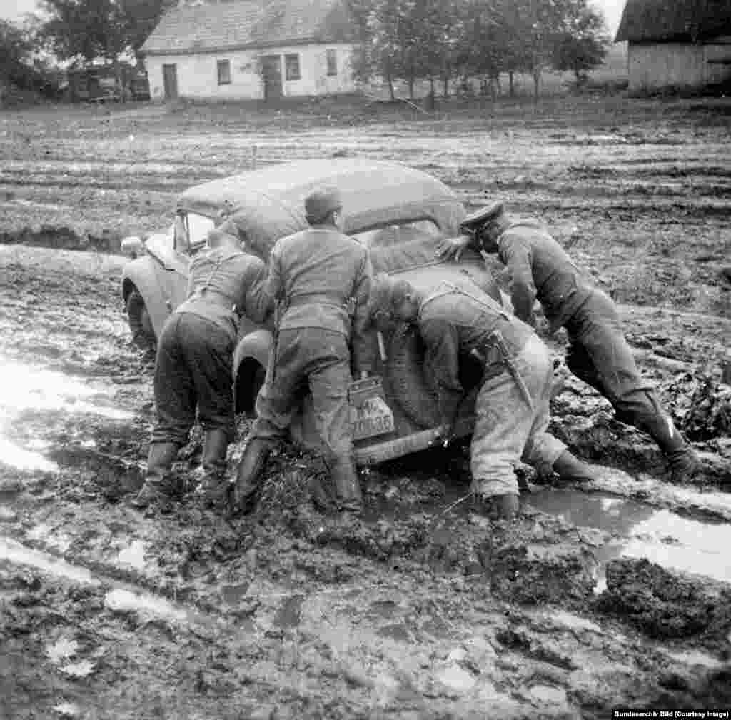 Німецькі офіцери намагаються витягти з болота машину, кінець 1941 року. Коли почалися осінні дощі, нацистські командири були змушені готуватися до затяжного конфлікту, бо бездоріжжя і запеклі радянські бійці гальмували наступ Німеччини