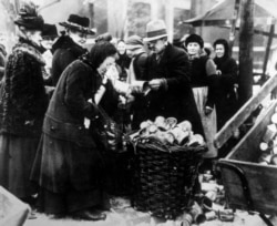 Жінка продає бляшанки на вулицях Берліна в 1923 році на тлі бідності та запаморочливої гіперінфляції