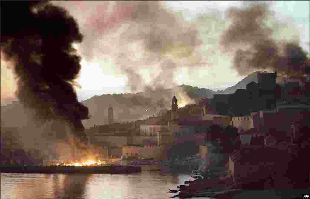 Хорватське місто Дубровник горить після бомбардування його ВПС Югославії в 1991 році. Від 1991-го до 2001 року колишню Югославію охопила серія міжетнічних воєн і заколотів, що закінчилися загибеллю щонайменше 130 тисяч людей і утворенням декількох незалежних держав-наступниць Югославії