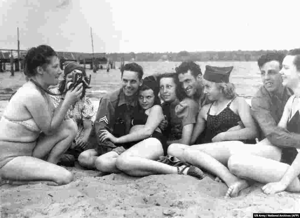 Американські солдати з німецькими дівчатами на берлінському озері Ванзеє в липні 1945 року, незабаром після прибуття американців до міста. Дружба з добре забезпеченими колишніми ворогами могла призвести до скандалів, але, як зауважила одна жінка в той час, &laquo;спочатку їжа, а потім мораль&raquo;