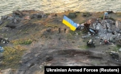 Українські бійці встановлюють національний прапор на острові Зміїний у Чорному морі (Одеська область), 7 липня 2022 року. Раніше, після тривалих інтенсивних ударів ЗСУ, російські військові, зазнавши великих втрат, залишили острів