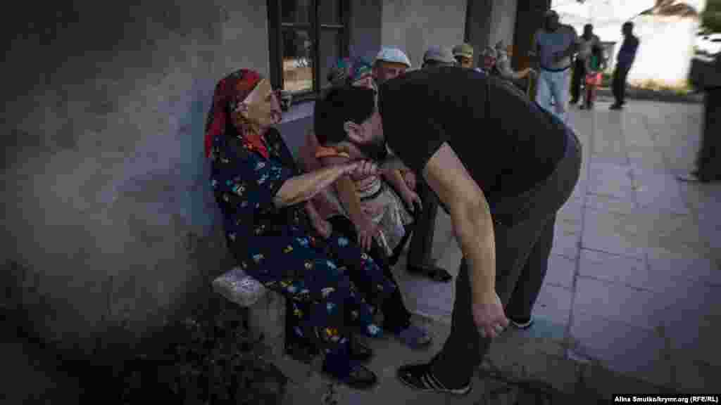 Молодий кримський татарин вітає старшу жінку на святі Курбан-байрам в Судаку, 2 вересня 2017 р. Фото Аліни Смутко