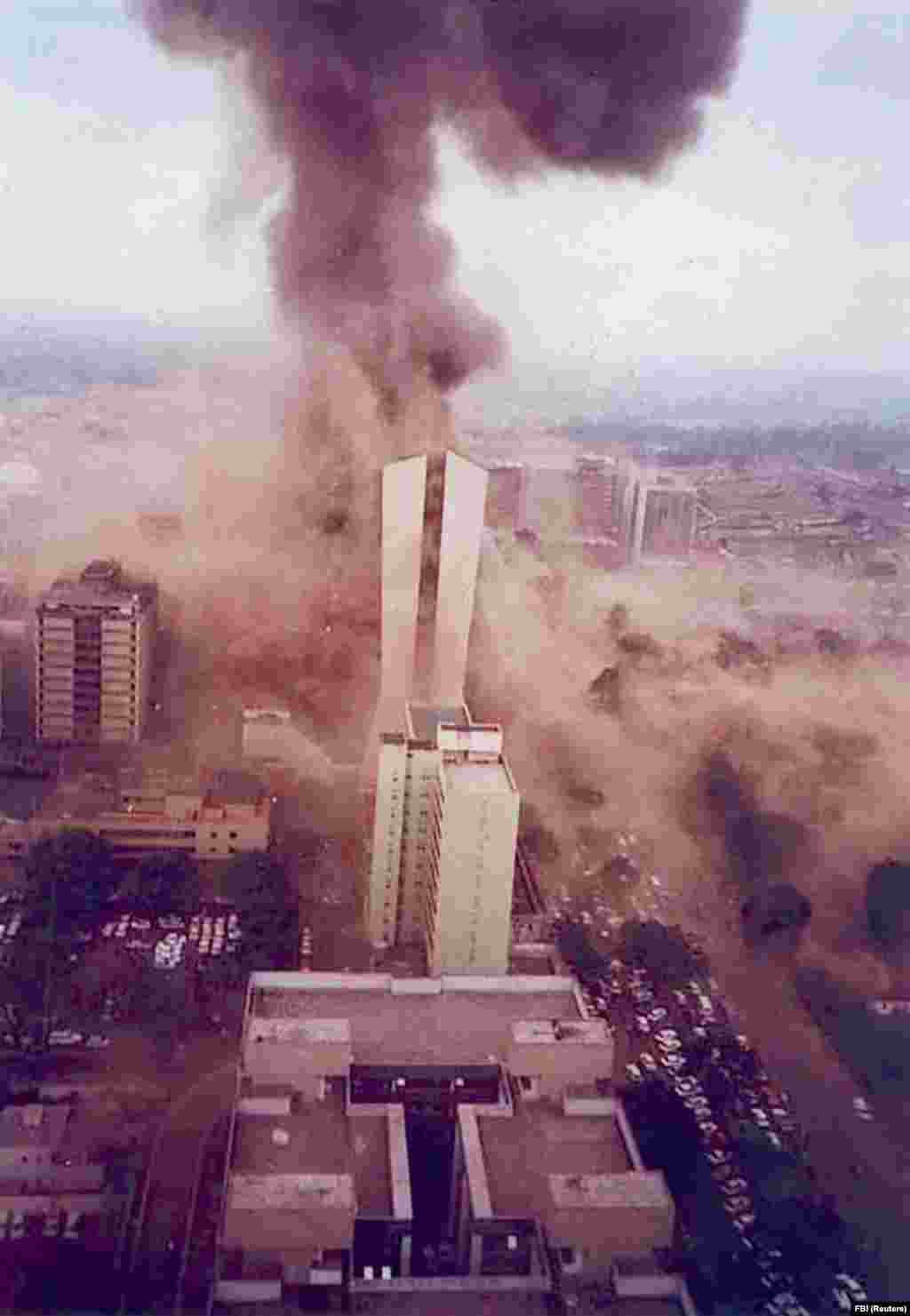 Стовп диму піднімається в небо через мить після вибуху бомби в вантажівці біля посольства США в Найробі, Кенія, у 1998 році. У 1990-х роках бін Ладен взяв на себе відповідальність за кілька терористичних атак, включаючи вибухи вантажівок в посольствах США в Кенії і Танзанії. Переважна більшість з 224 осіб, які загинули в результаті терактів, були місцевими африканцями